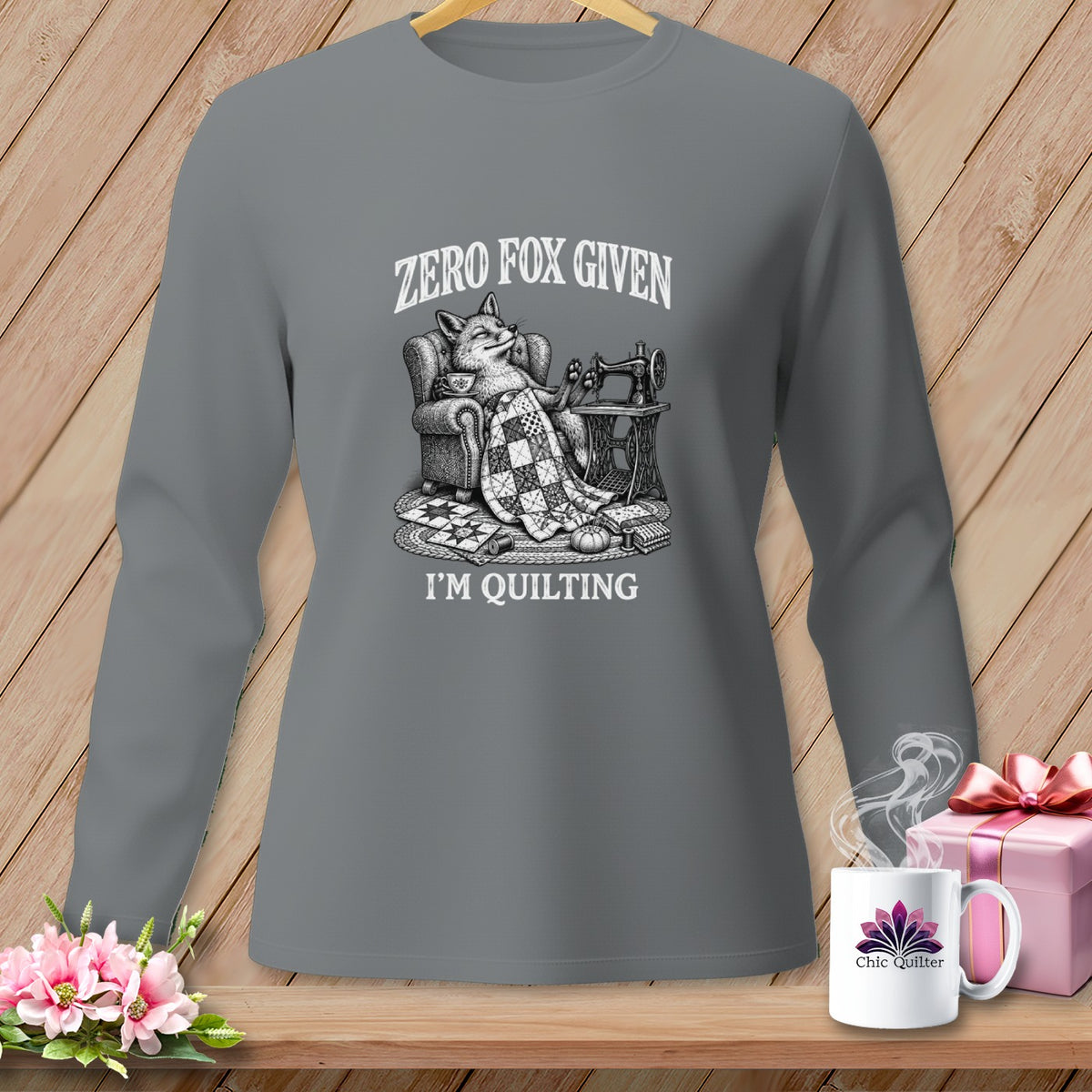Grey long-sleeve shirt with a fox, sewing machine, quilt, and text "ZERO FOX GIVEN I'M QUILTING".