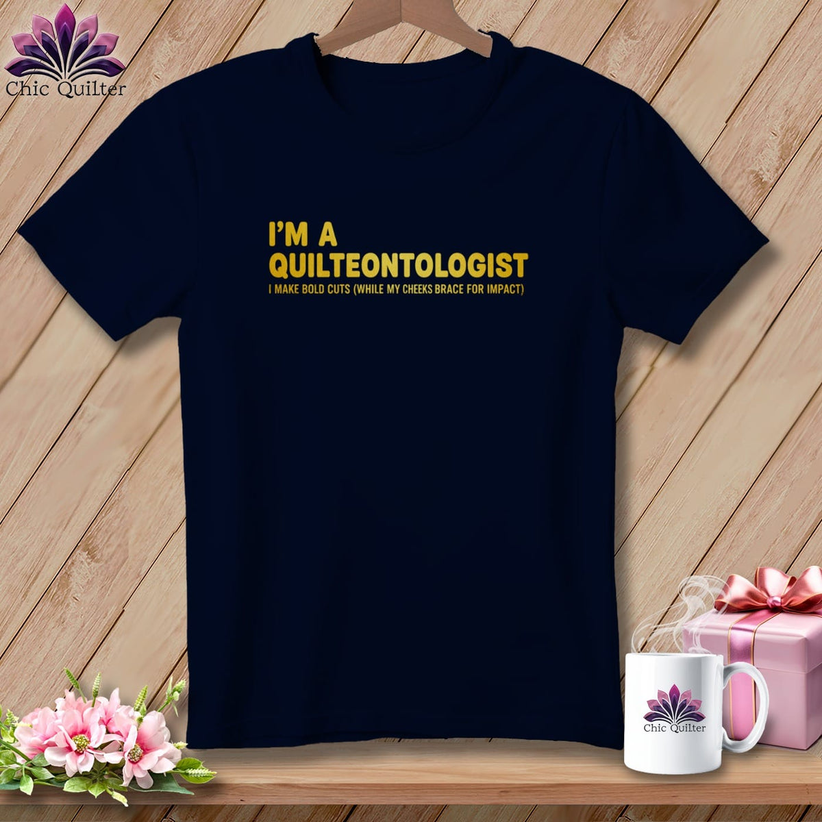 Navy t-shirt with yellow text: "I'M A QUILTEONTOLOGIST I MAKE BOLD CUTS (WHILE MY CHEEKS BRACE FOR IMPACT)".