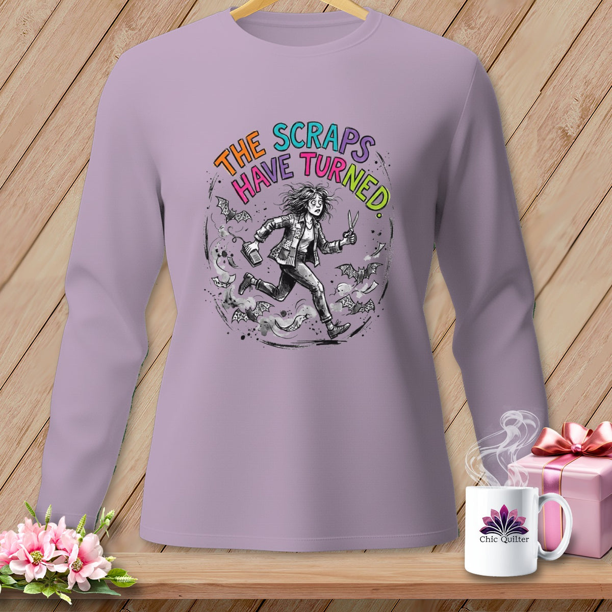 Lilac long-sleeve shirt with "The Scraps Have Turned" graphic and running figure.