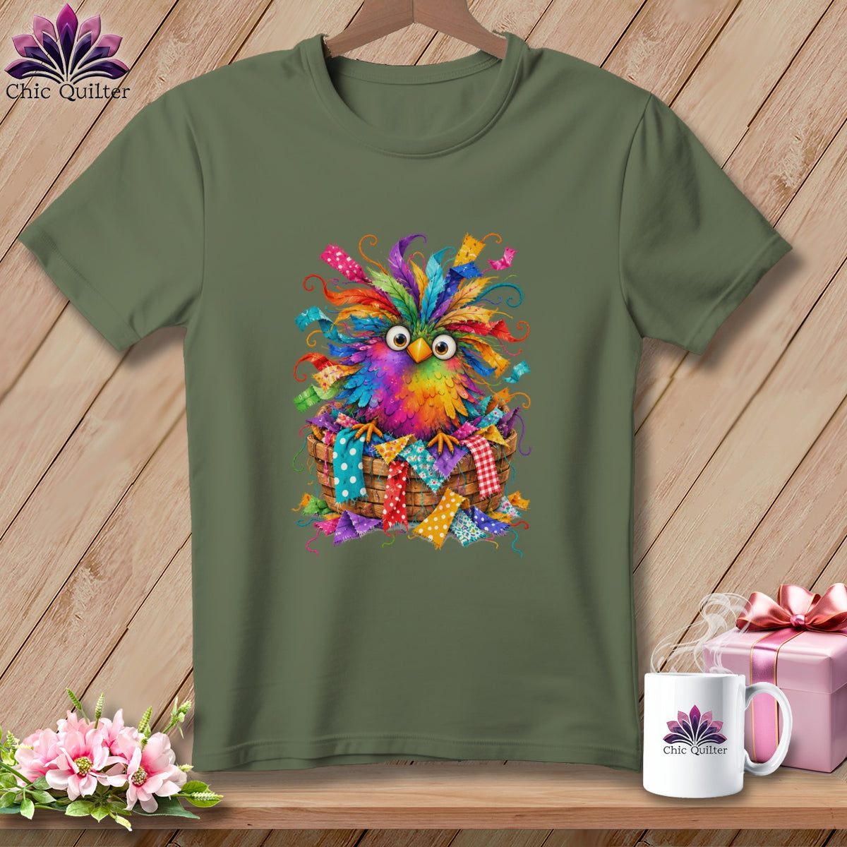 An olive green t-shirt displays a graphic of a colorful, feathered bird sitting in a basket.
