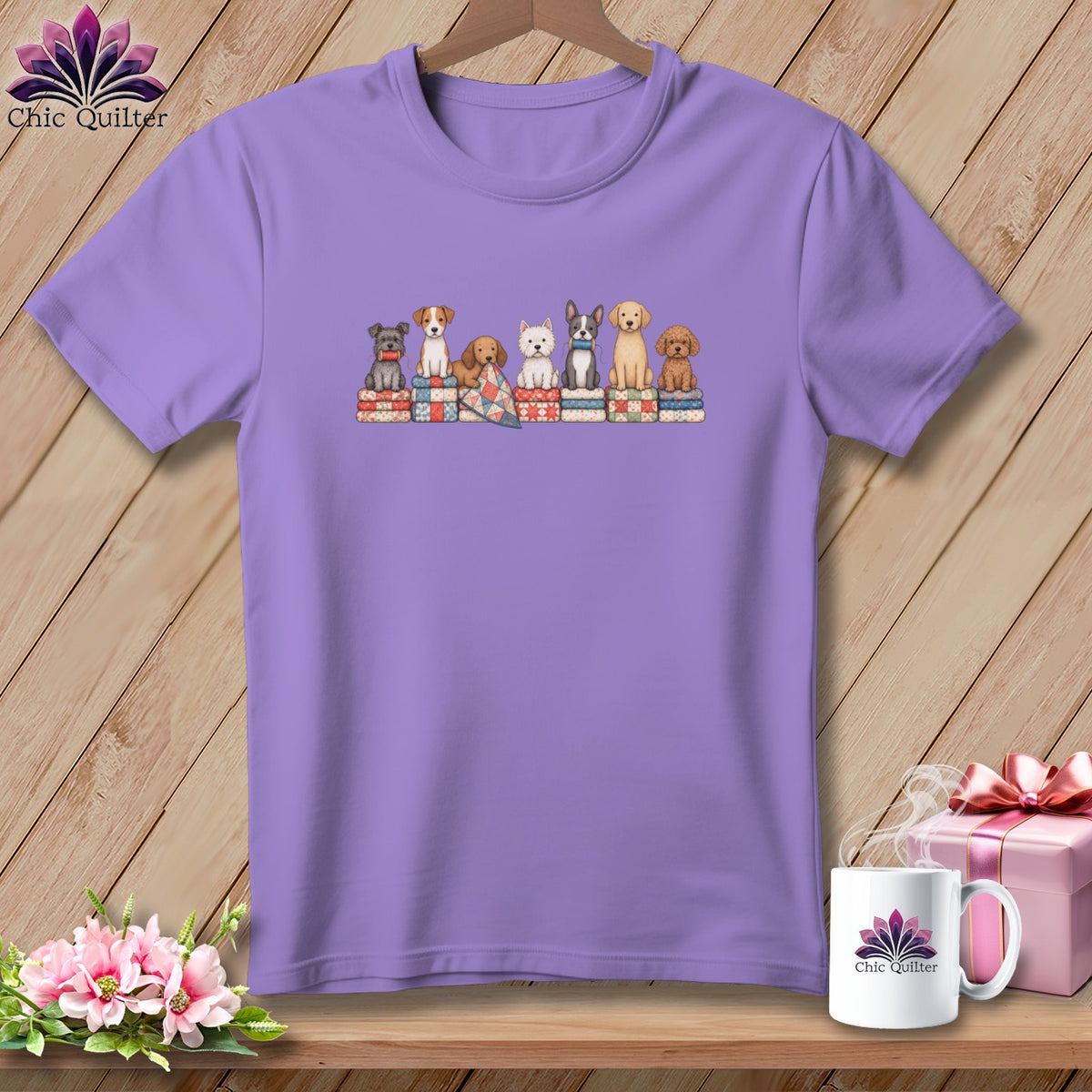 A purple crewneck t-shirt featuring an illustration of seven dogs sitting on colorful stacked quilts.