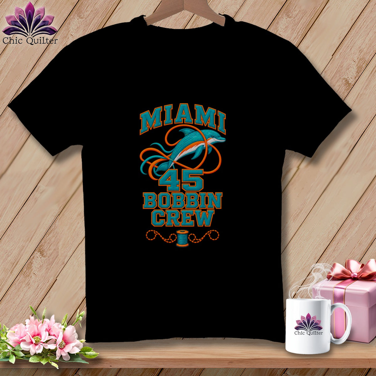 Black t-shirt featuring a Miami Bobbin Crew graphic with a dolphin and sewing elements.