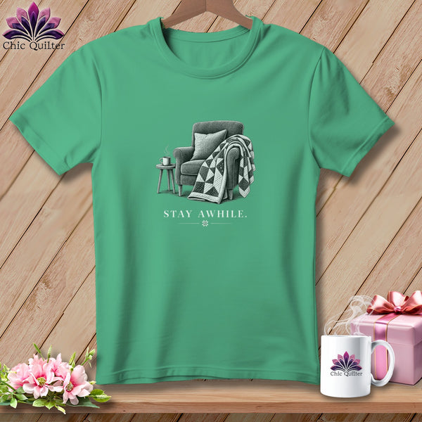 Green t-shirt with an illustration of an armchair and the text "STAY AWHILE."
