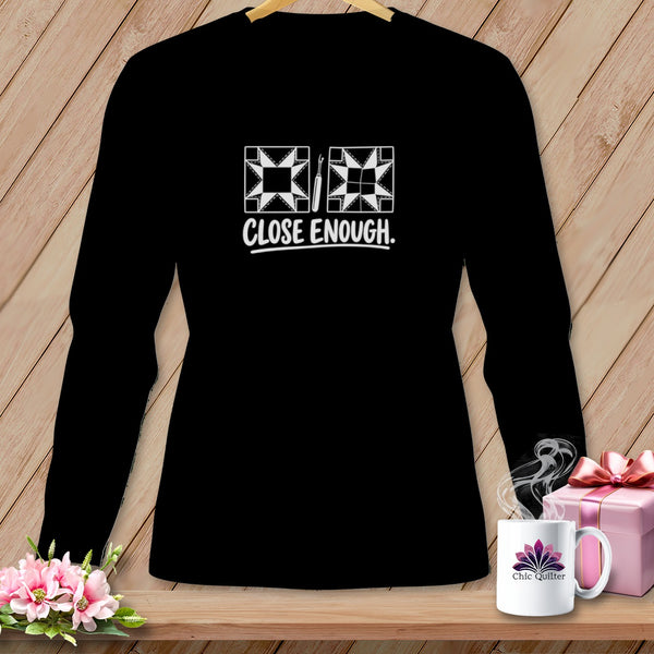 Black long-sleeve shirt with quilting design and "CLOSE ENOUGH." text.