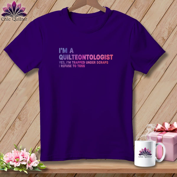 Purple t-shirt with text "I'M A QUILTEONTOLOGIST YES, I'M TRAPPED UNDER SCRAPS I REFUSE TO TOSS".