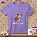A purple t-shirt featuring a graphic of a mouse wearing a cape and holding a seam ripper, with the text WE RIP AT DAWN.