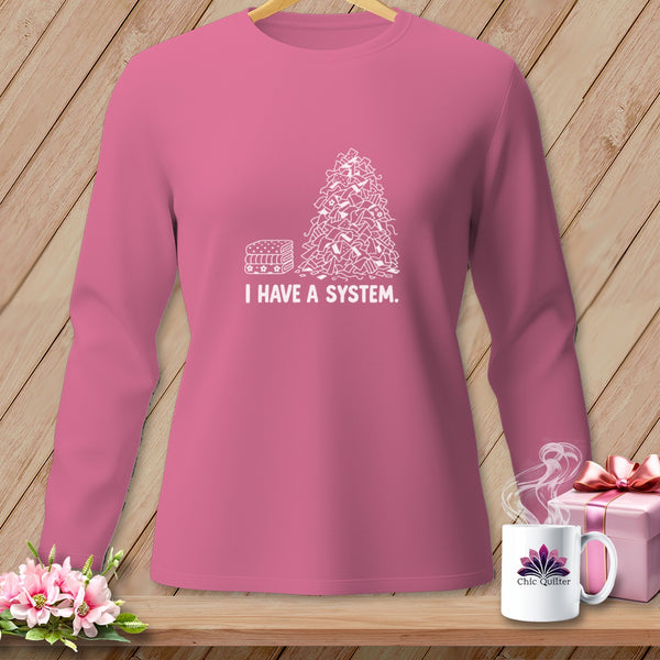 Pink long sleeve shirt with "I HAVE A SYSTEM." graphic and fabric pile.