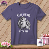Purple t-shirt featuring a hedgehog illustration holding a quilt and the text Sew What? Bite Me.