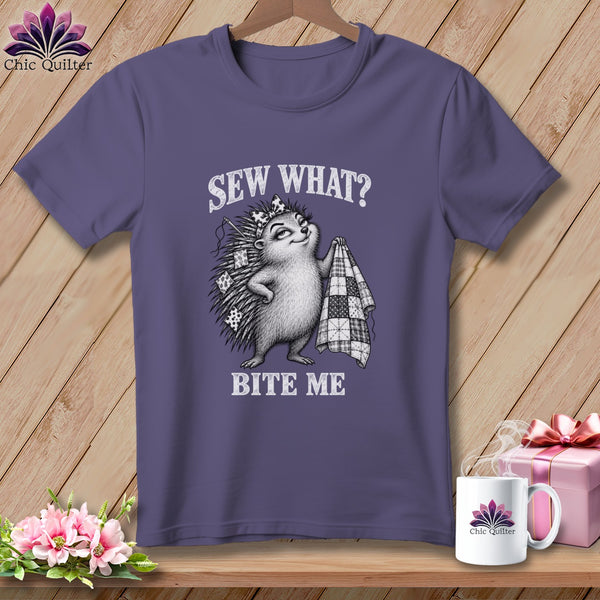Purple t-shirt featuring a hedgehog illustration holding a quilt and the text Sew What? Bite Me.