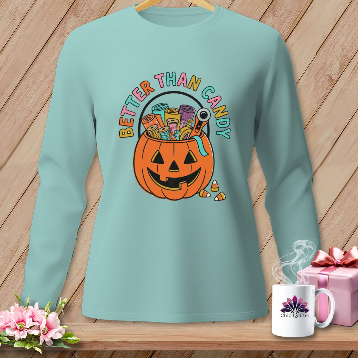 Light blue long-sleeve shirt with a jack-o'-lantern filled with sewing supplies and "Better Than Candy" text.