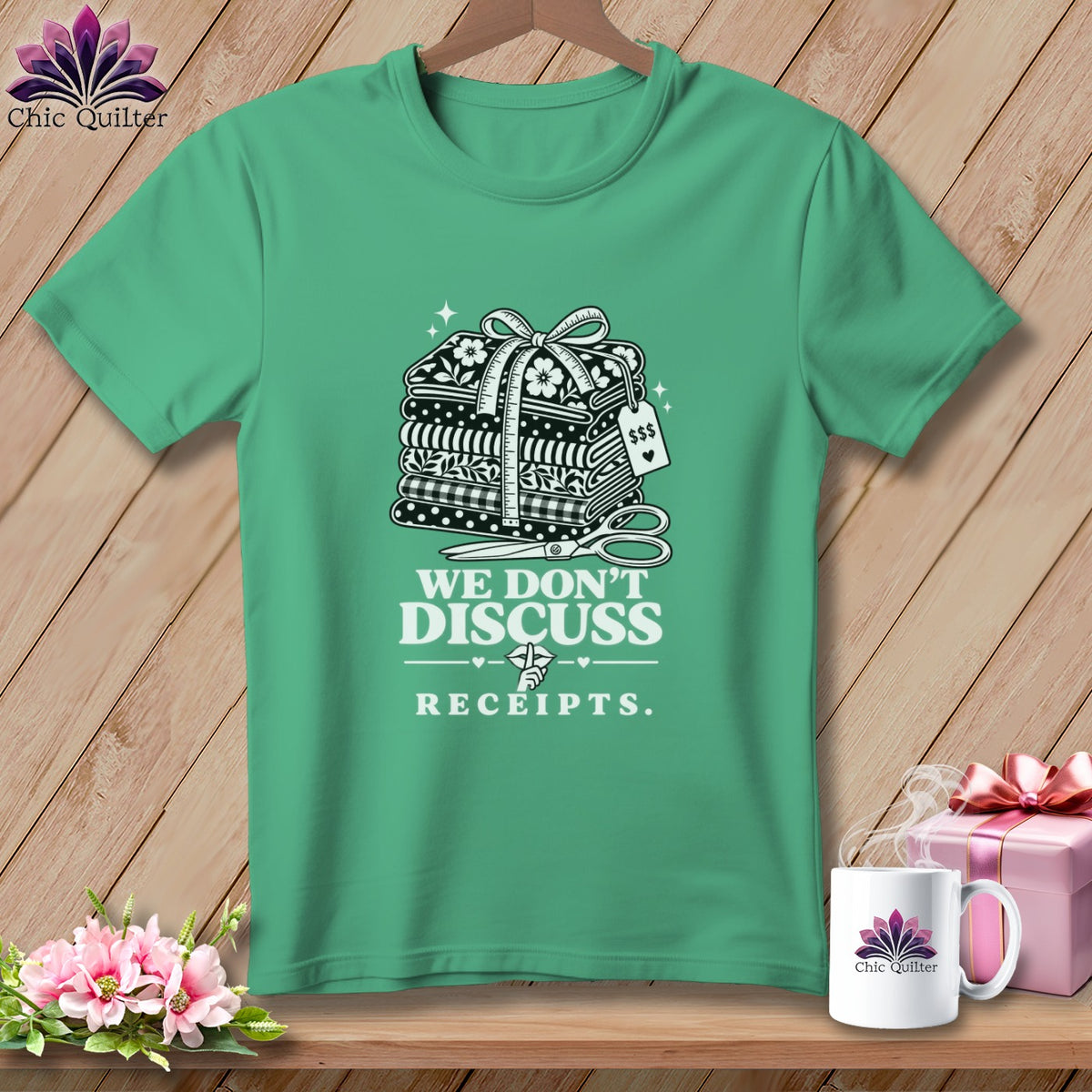 Green t-shirt with fabric stack, scissors, and text "We Don't Discuss Receipts."