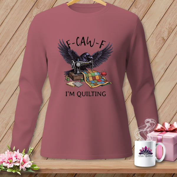 Long-sleeve shirt with crow, sewing machine, quilt, and text "F-CAW-F I'M QUILTING".