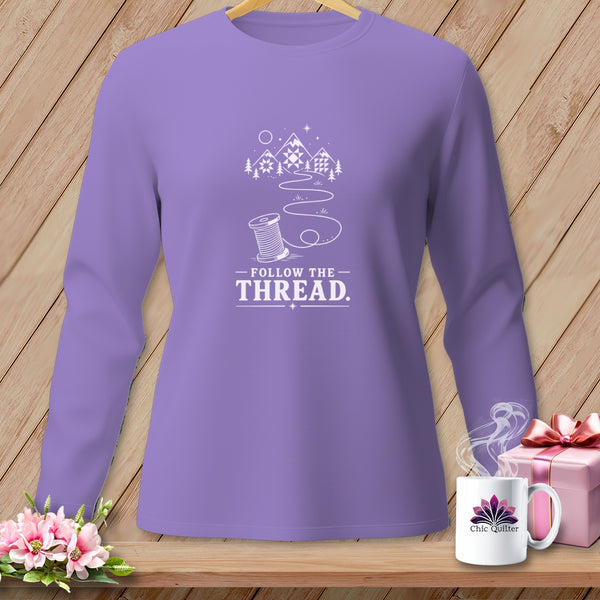 Lavender long-sleeve shirt with "Follow the Thread" and mountain, spool design.