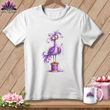 A white t-shirt hanging on a wooden wall displays a graphic of a whimsical purple bird standing on a thread spool.