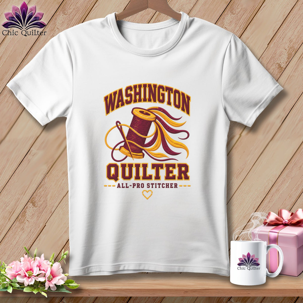 A white t-shirt featuring a quilting graphic and the text "Washington Quilter All-Pro Stitcher".