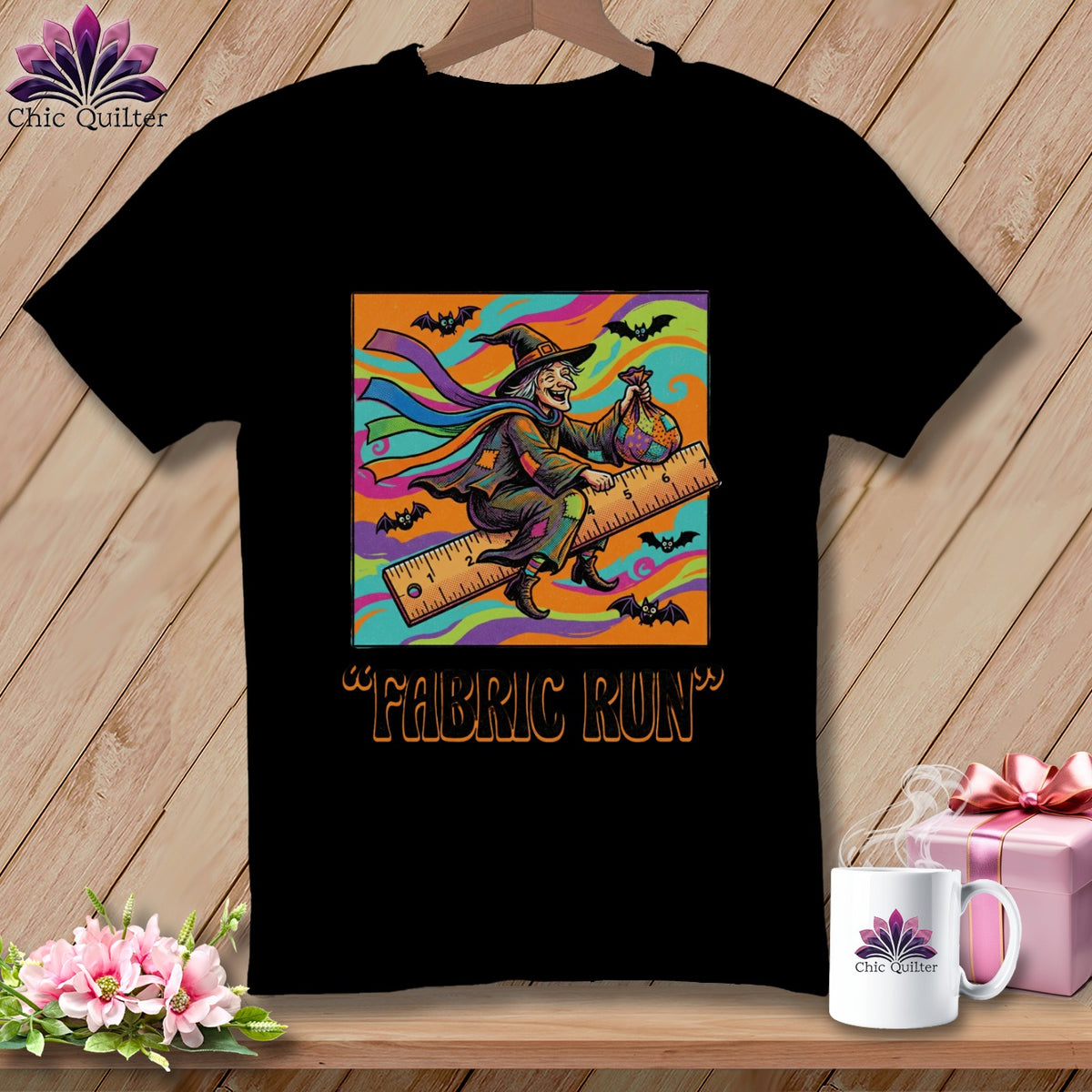 Black t-shirt with a cartoon witch riding a ruler, holding a fabric bag, with bats.