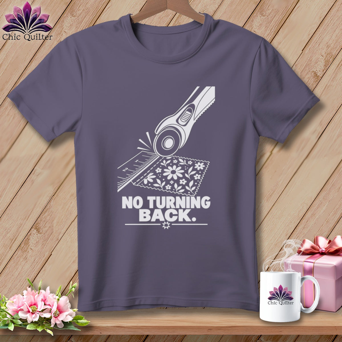 Gray t-shirt with white graphic of rotary cutter, ruler, fabric, and text "NO TURNING BACK."