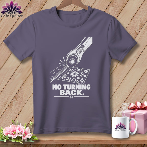 Gray t-shirt with white graphic of rotary cutter, ruler, fabric, and text "NO TURNING BACK."