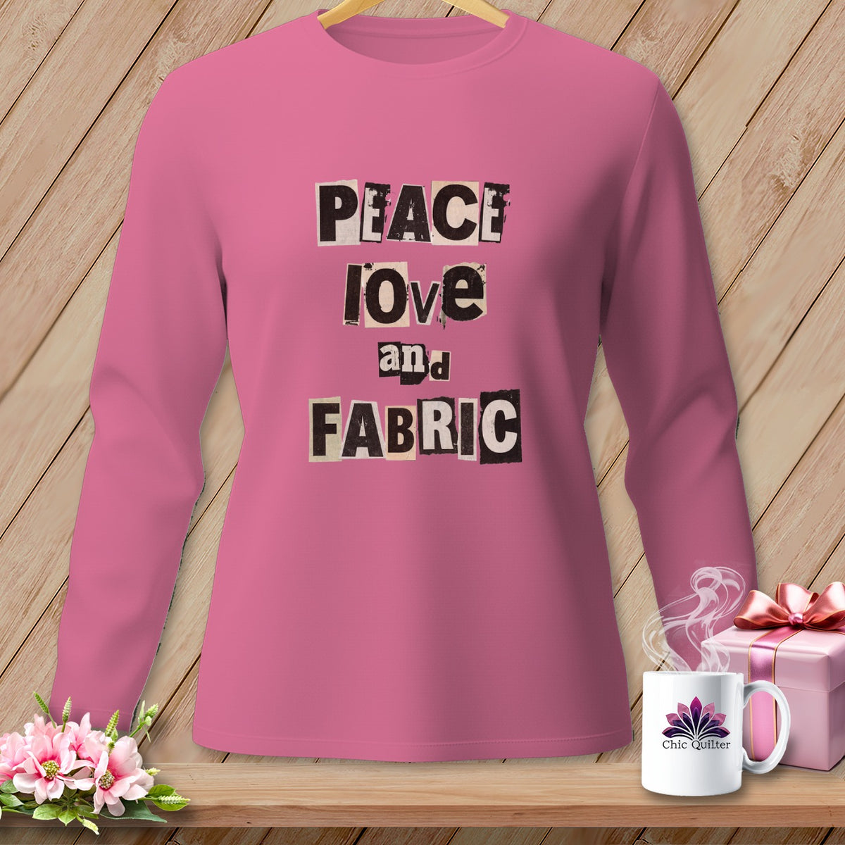 Pink long-sleeve shirt with "PEACE love and FABRIC" text in cutout letters.