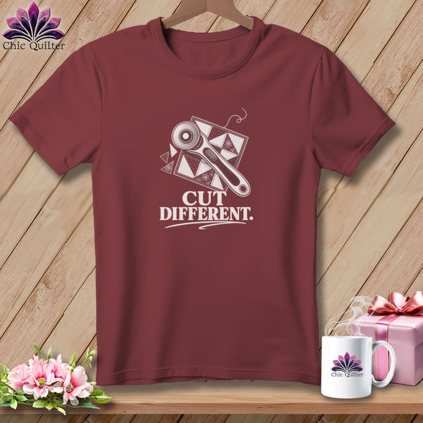 Maroon t-shirt with white graphic of rotary cutter, quilt pieces, and text "CUT DIFFERENT".