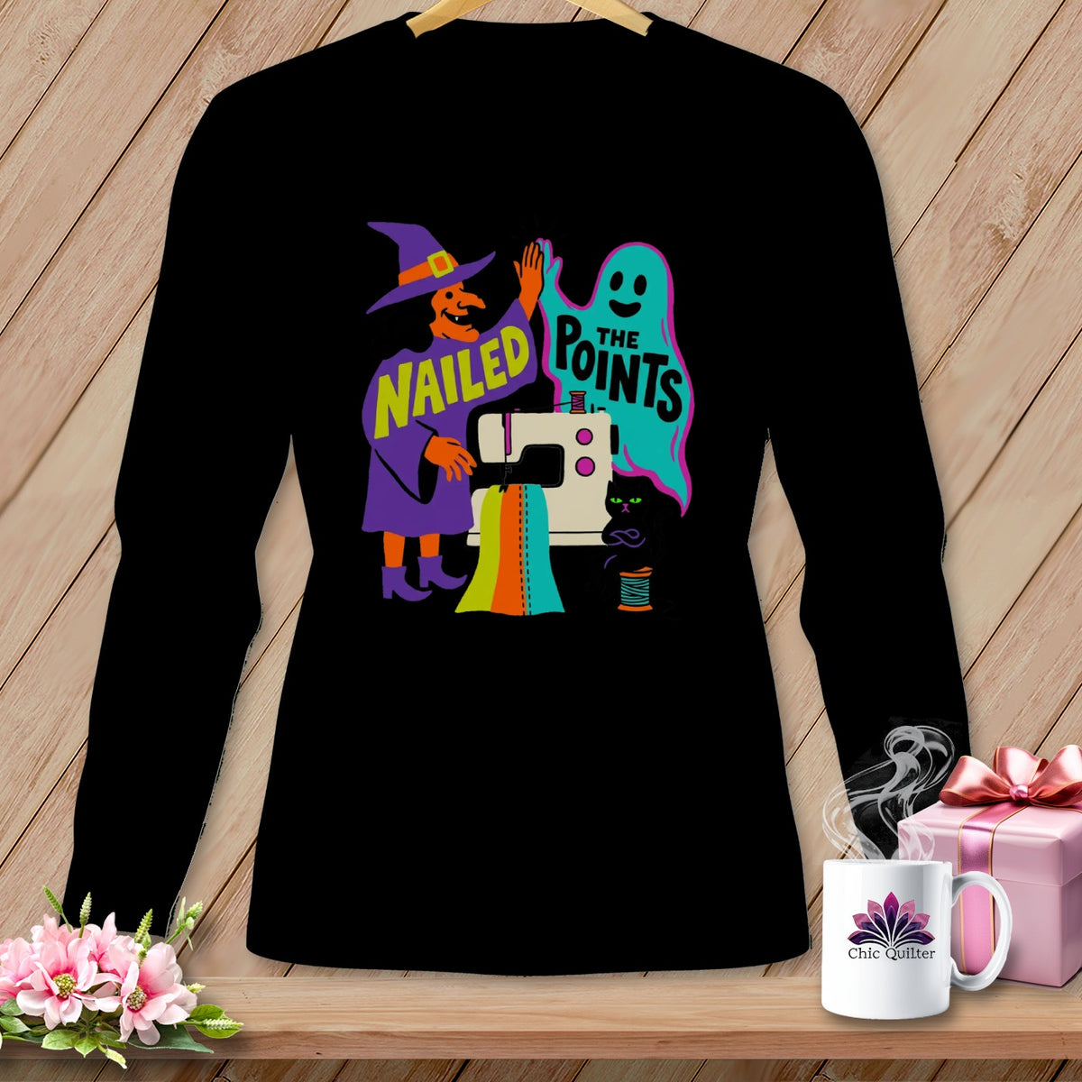 Black long-sleeve shirt with witch, ghost, and sewing machine Halloween graphic.