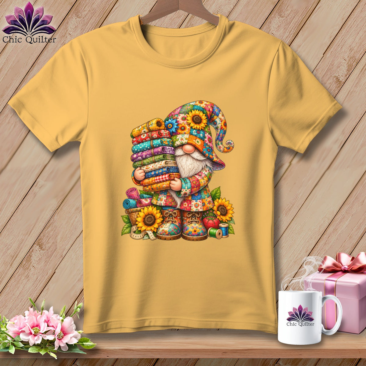 Golden-yellow t-shirt featuring a colorful graphic of a gnome holding a tall stack of folded fabrics.