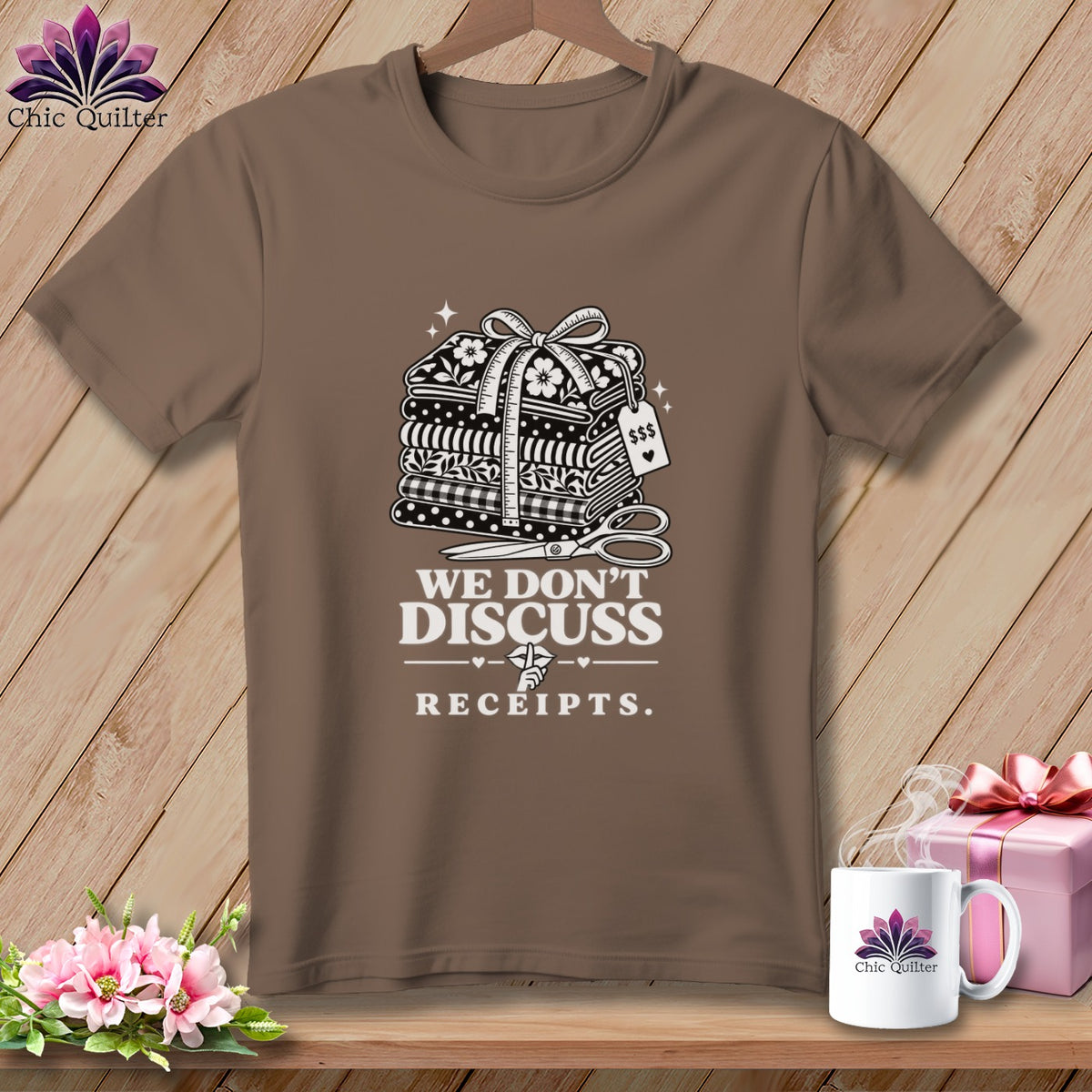 Brown t-shirt with stack of fabrics, scissors, and text "WE DON'T DISCUSS RECEIPTS."