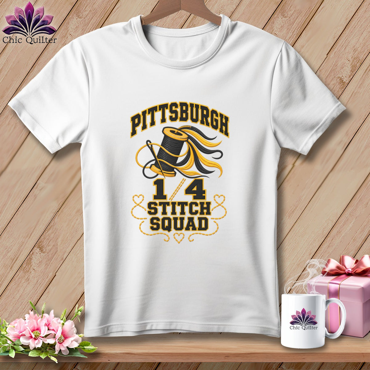 A white t-shirt on a wooden background features text reading "Pittsburgh 1/4 Stitch Squad" with a spool of thread graphic.