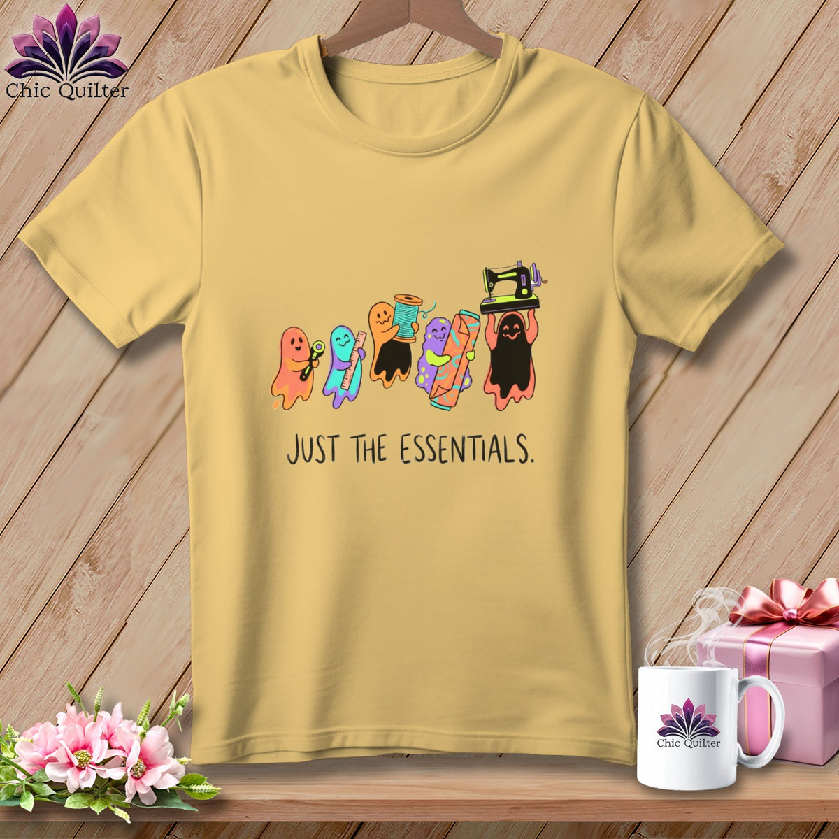Yellow t-shirt with ghosts holding sewing supplies and text "JUST THE ESSENTIALS."