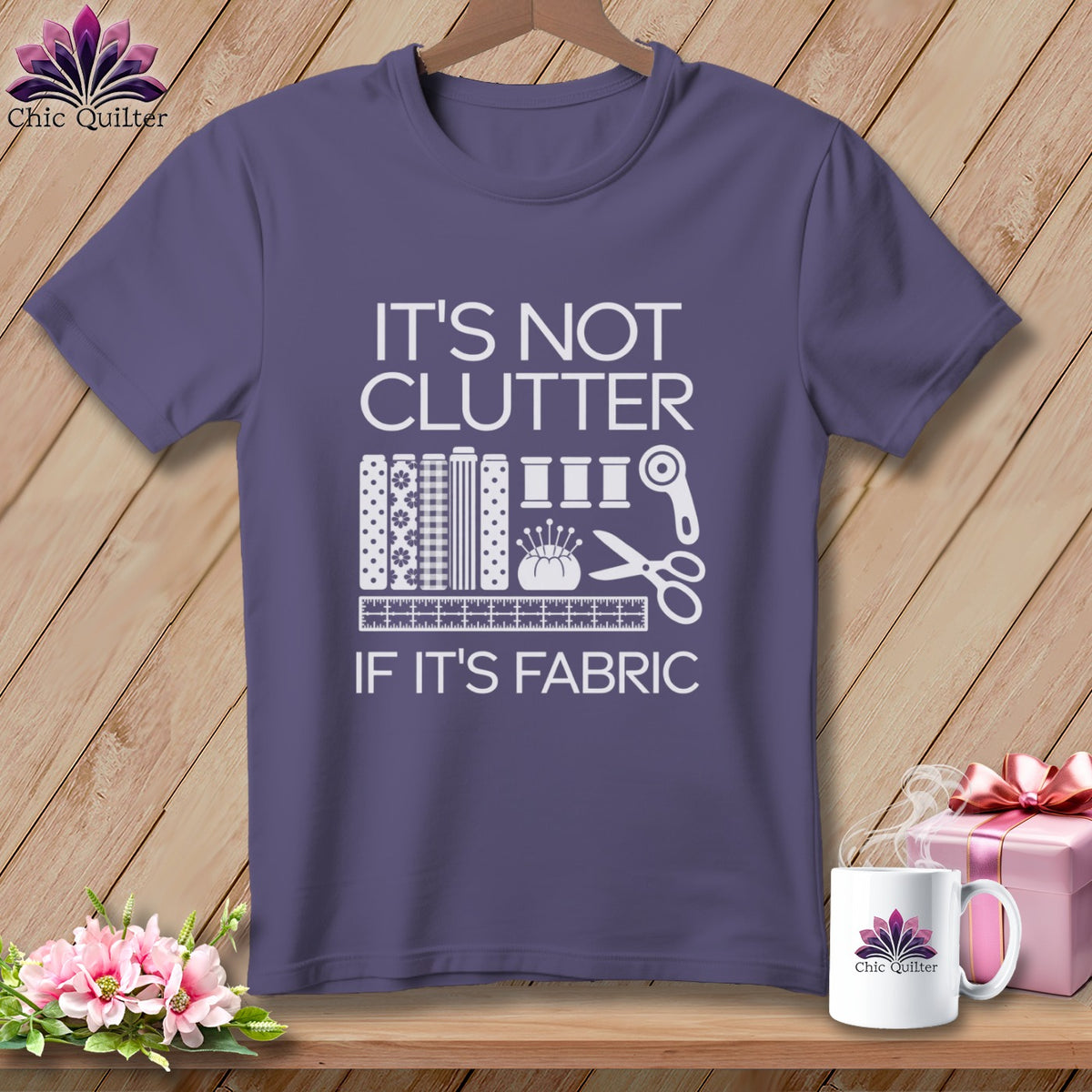 Purple t-shirt with "It's Not Clutter If It's Fabric" and sewing icons.