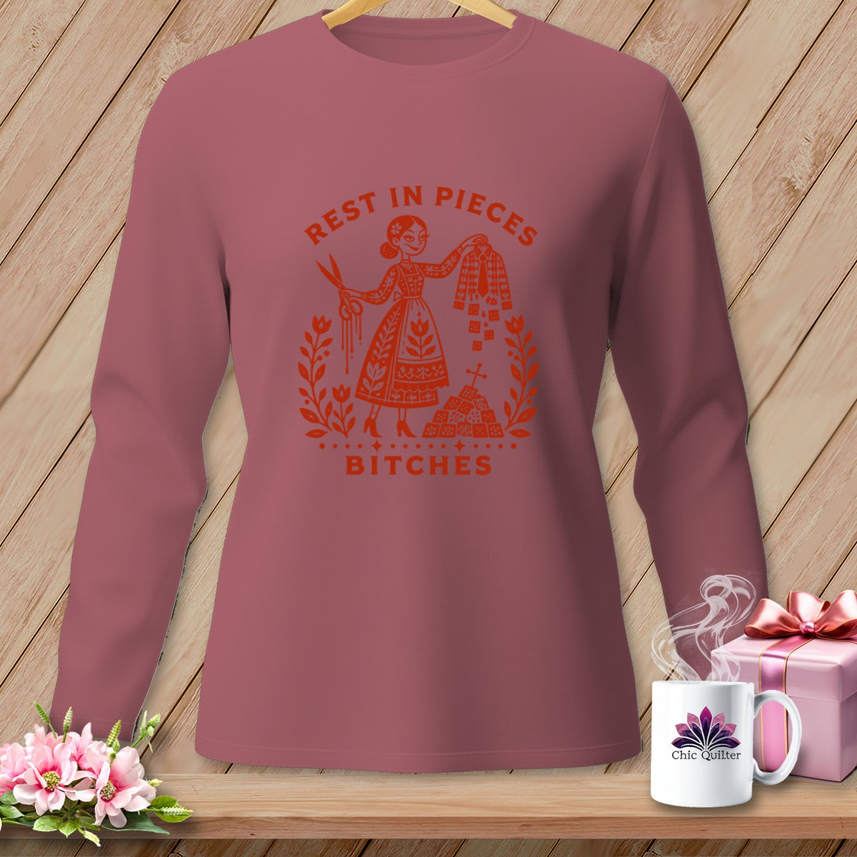 Rose long-sleeve shirt with "Rest in Pieces Bitches" graphic and scissors.