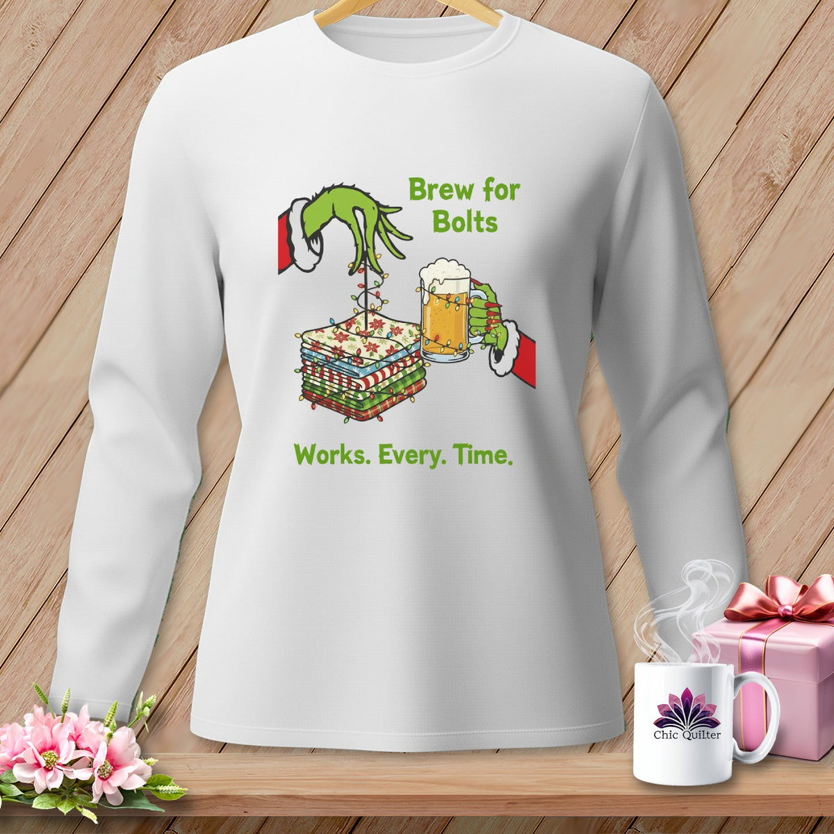 White long-sleeve shirt with Grinch-like hands, fabric bolts, beer, and text.