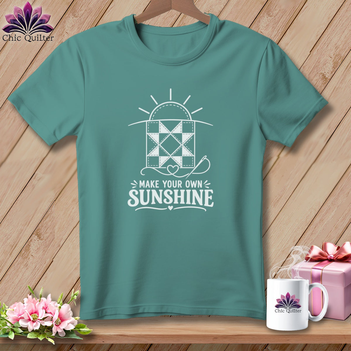 Teal t-shirt with "Make Your Own Sunshine" quilt design and sewing needle.
