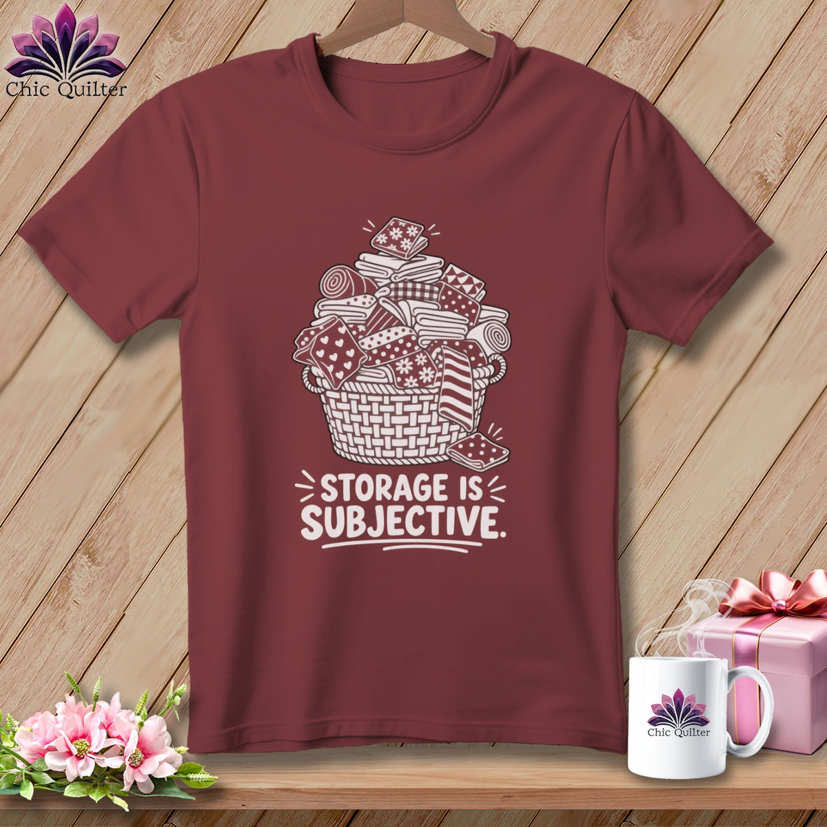 Maroon t-shirt with a white graphic of a basket overflowing with fabric. Text reads "STORAGE IS SUBJECTIVE."