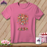 A pink crew-neck t-shirt featuring a whimsical illustration of a girl surrounded by sewing supplies.