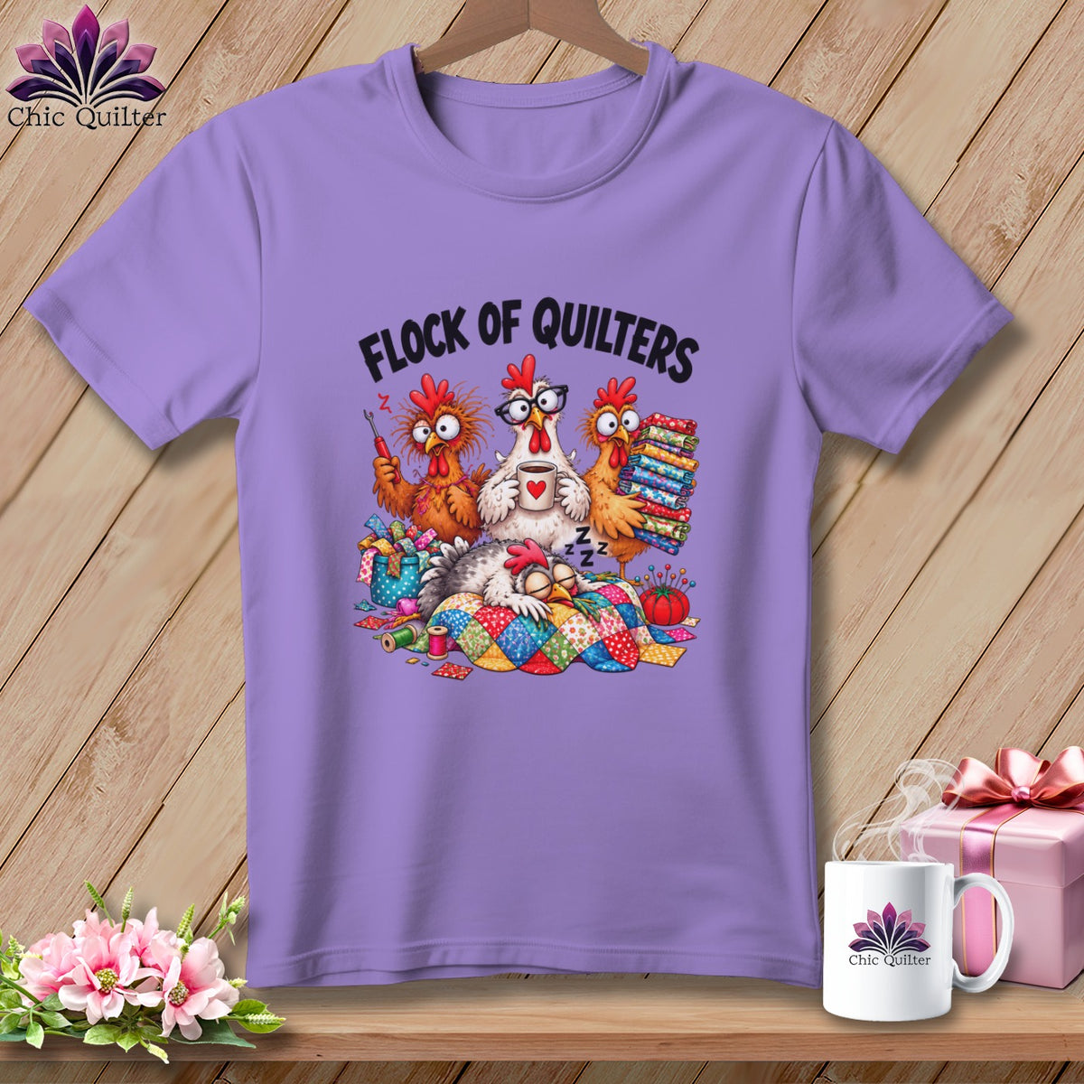 A light purple t-shirt featuring a cartoon graphic of four chickens and the text "FLOCK OF QUILTERS".