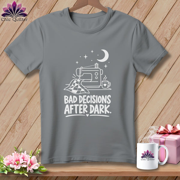 Gray t-shirt with white graphic of sewing machine, fabric, moon, and text "BAD DECISIONS AFTER DARK."