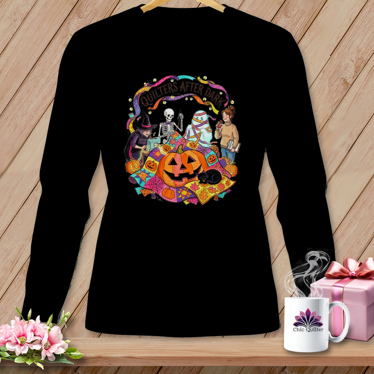 Black long-sleeve shirt with a Halloween quilting graphic and text "Quilters After Dark."