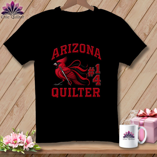A black t-shirt features a red cardinal graphic holding a sewing needle, along with the text Arizona Quilter 14.