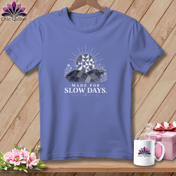 Purple t-shirt with "Made for Slow Days" text and quilt-inspired landscape.