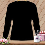 Black long sleeve shirt on hanger with mug, gift box, and flowers.