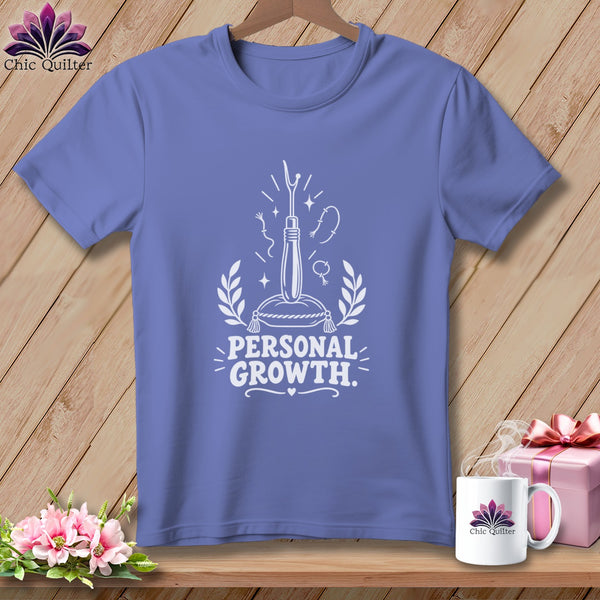 Lavender t-shirt with white graphic of a seam ripper, sewing notions, and text "PERSONAL GROWTH."