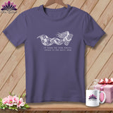 Purple t-shirt with graphic of a mermaid holding fabric, and text about a quilt shop.