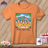 Orange t-shirt featuring a graphic of four hula-dancing penguins on a beach, text reading Aloha Quilt Bee.