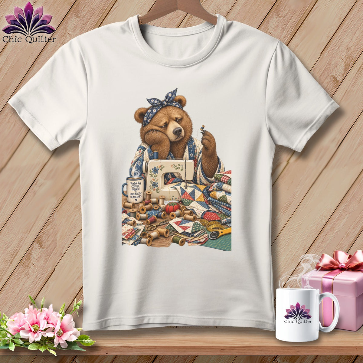 Bear with sewing machine, fabric scraps, and mug reading "Fueled by Coffee, Fabric, Unrealistic Deadlines."