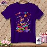 Purple t-shirt with cartoon witch surrounded by Halloween fabric rolls and text 