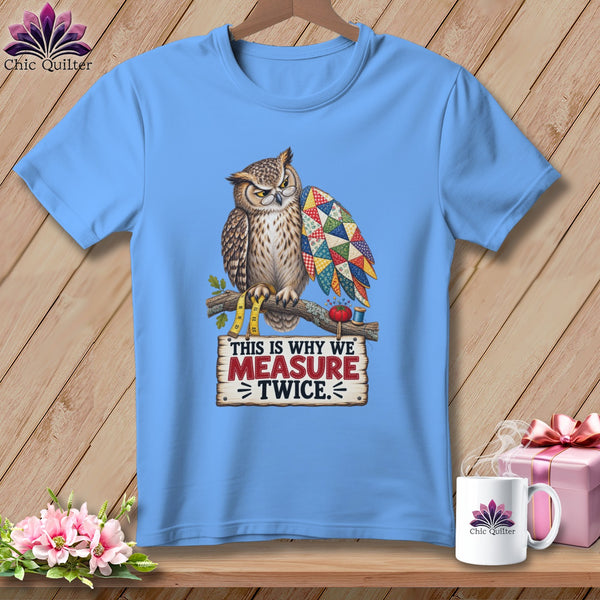 Light blue t-shirt with owl holding a quilt and text "This is why we measure twice."