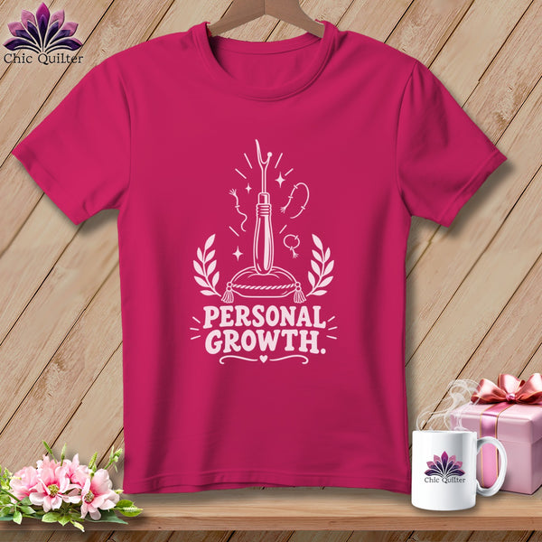 Fuchsia t-shirt with white graphic of a seam ripper and text "PERSONAL GROWTH."