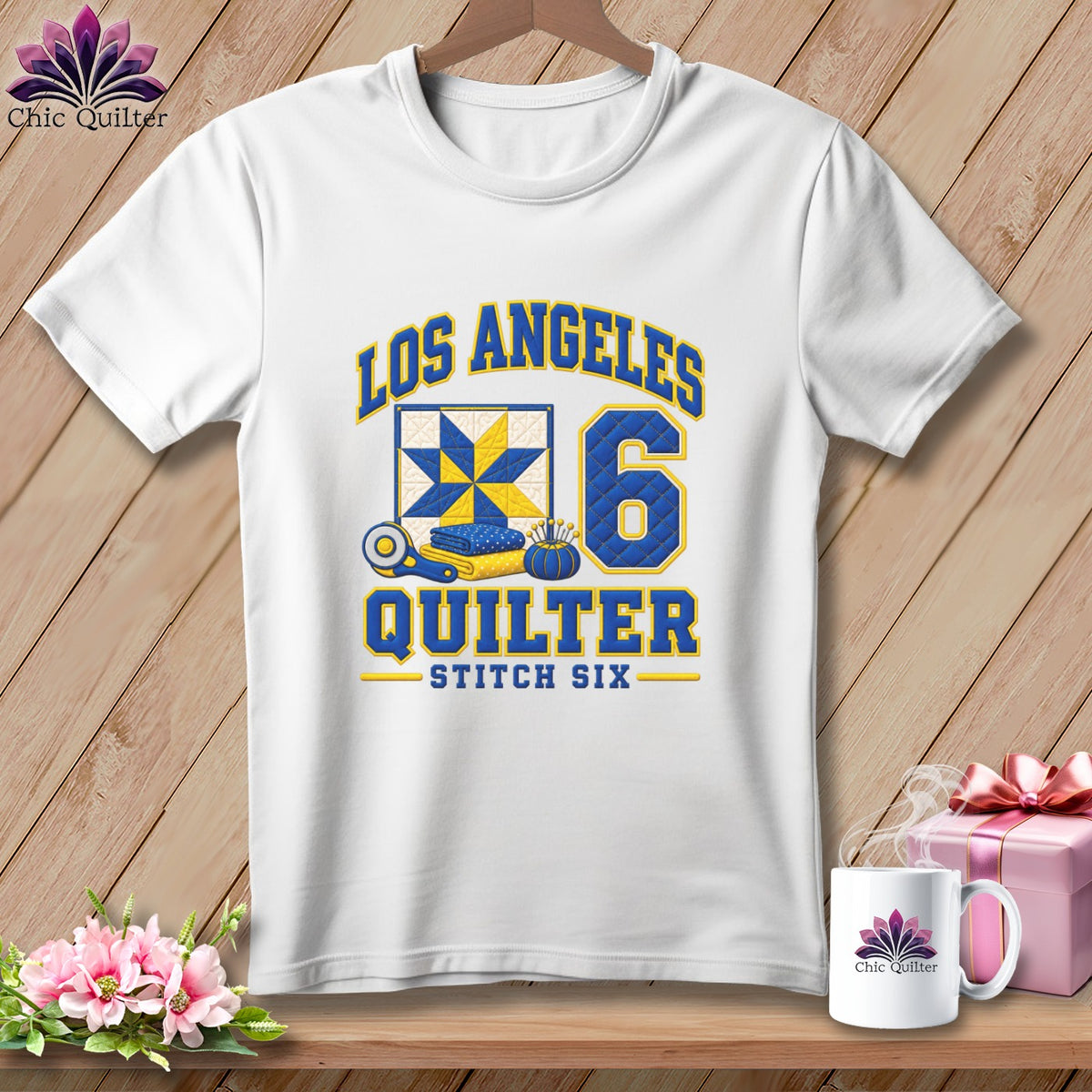 White t-shirt with Los Angeles Quilter graphic, quilt block, number six, and sewing tools.