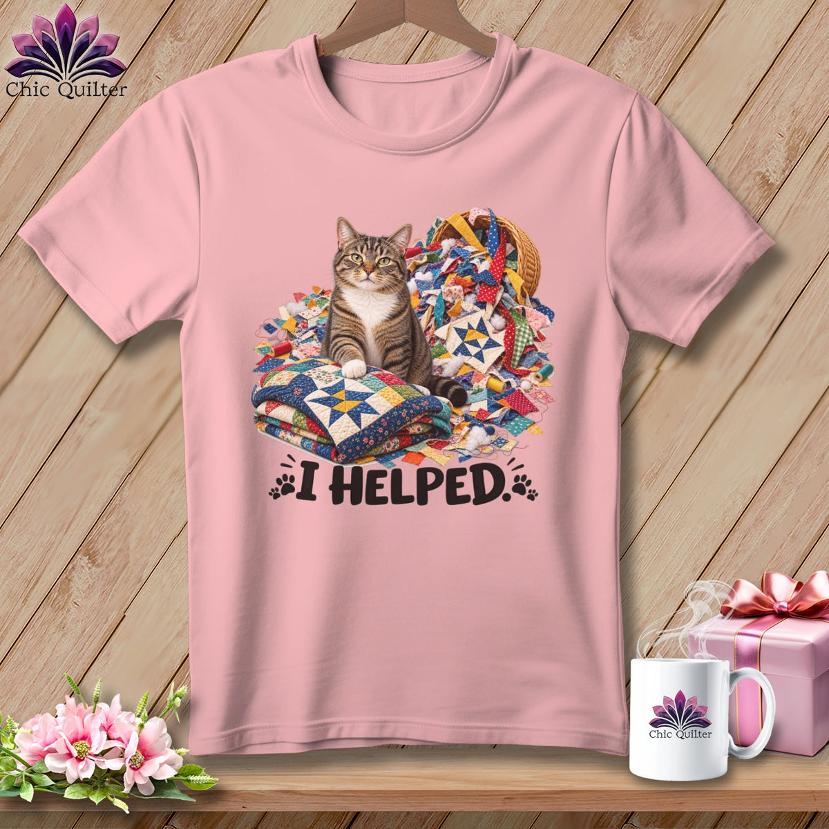 Pink t-shirt with a tabby cat sitting on quilts and fabric scraps, text "I HELPED."
